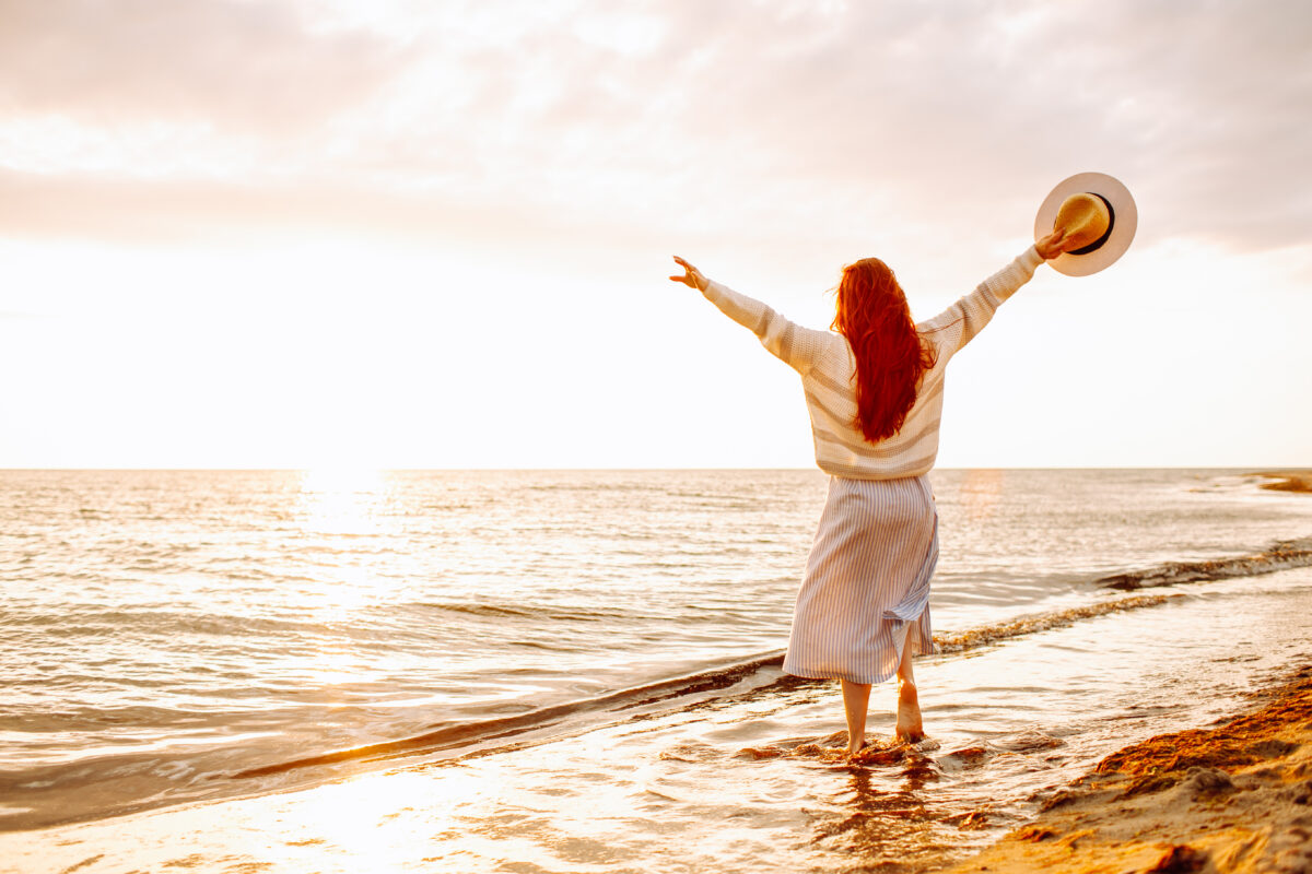 young woman at beach at sunrise looking to make a fresh start in life