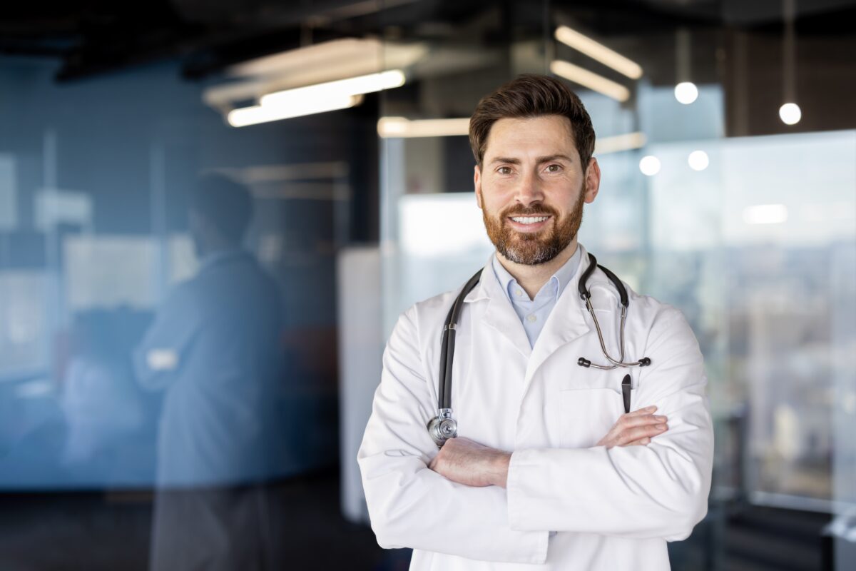 male doctor standing in medical practice in white coat